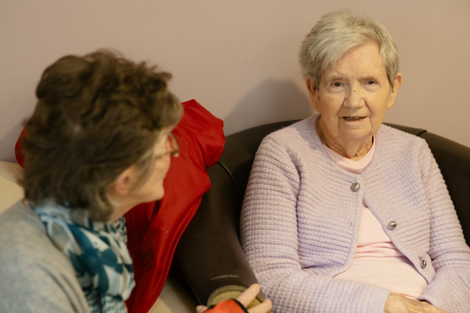 Two elderly women sitting and talking