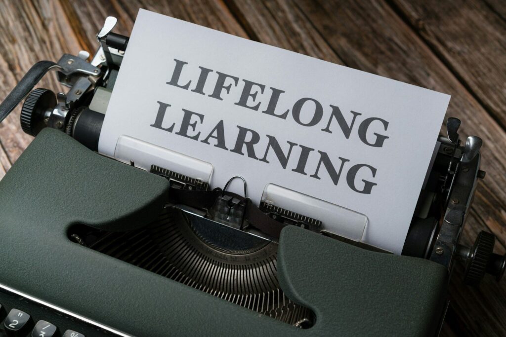 a close up of a typewriter with a paper that says lifelong learning