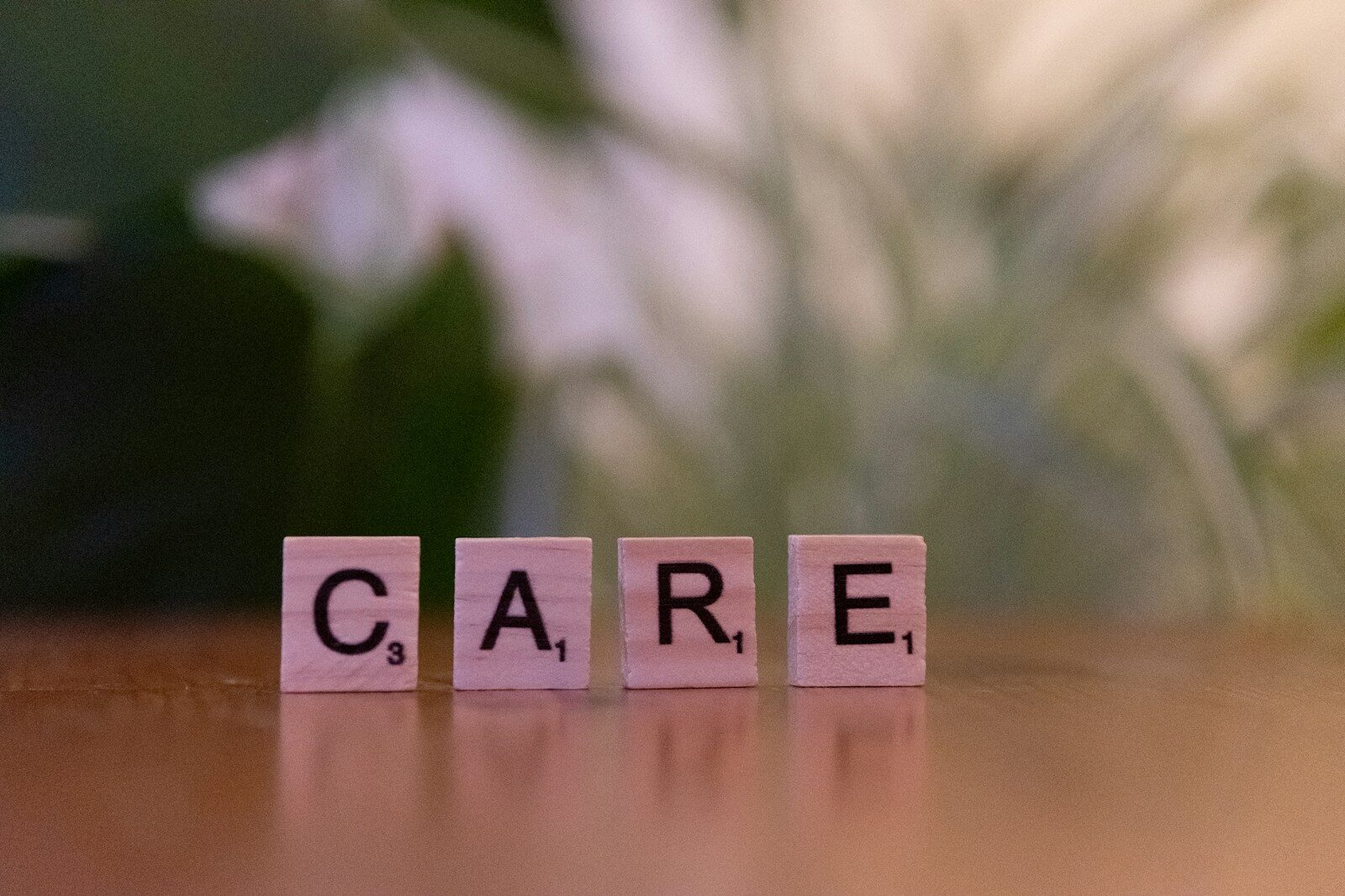 A wooden block spelling care on a table